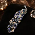 Detailed peacock brooch featuring vibrant multicolored rhinestones in a silver finish - Purple Multi-color