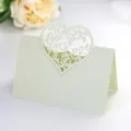 Macro shot of laser cut pearl white place card with Only Love heart design for wedding - Pearlescent Beige