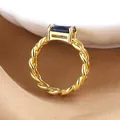 Detail of a gold twisted band ring with a rectangular blue gemstone in four-prong setting - Gold Blue Stone