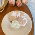 Pale pink satin scrunchie with white rose detail and green leaves on a white plate - Camellia Hair Tie / Light Pink Camellia