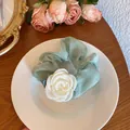 Light green fabric scrunchie with white camellia flower on a white ceramic plate - Camellia Hair Tie / Emerald Green Camellia
