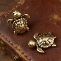 Macro shot of two vintage brass turtle figurines with detailed heart shell patterns - Turtle