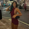 Close-up of deep red sequin halter romper with open back design in urban night setting - S / Burgundy