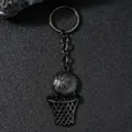 Détail du porte-clés panier de basket noir mat sur fond en pierre texturée - Noir
