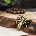 Detailed macro view of solid brass octopus figurine pendant on a natural wood surface - Medium Octopus
