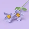 Handmade crochet light purple flowers with green stems on a soft lilac background - Mao Si Cornus Flower - Purple