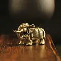 Macro shot of vintage brass elephant statue with detailed floral saddle engraving - Curled Trunk Elephant