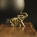 Macro shot of detailed brass elephant incense holder on a premium wooden base - Tilted Trunk Elephant Statue / Bronze