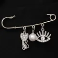 Silver safety pin brooch featuring a rhinestone cat, white pearl, and evil eye charm - White K 6445 (Cat and Eye)