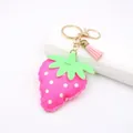 Close-up of pink leather strawberry keychain with white dots and a tassel detail - Fluorescent Rose Red Strawberry Style