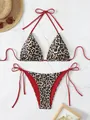 Two-piece leopard print bikini with red ties and halter neck on stone background - Black Brown Leopard Red