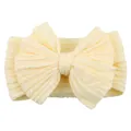 Pale yellow elastic baby headband featuring a large knitted bow and cable pattern - Beige