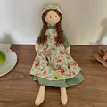 Handmade fabric doll in green dress and floral apron with brown braided hair - Green Floral Dress Style
