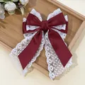Detail of burgundy satin and white lace double-layered bow hair clip on a wooden tray - Burgundy