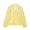 Close-up of V-neck ruffle detailing and white buttons on a pale yellow satin shirt - Yellow