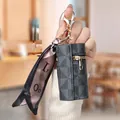 Mini portamonete cilindrico con motivo monogramma grigio e chiusura a moschettone dorata - Nero
