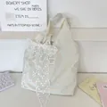 Detail of green canvas tote bag featuring a yellow cat print and large white lace bow - Green Cat Print With White Flower