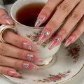 Detail of almond-shaped nails with pink flowers and silver star rhinestones on a tea cup - Maple Leaf Pink Floral Style (XY-01)