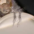 Silver heart earrings with elegant long snake chain tassels on a ceramic plate - Hammered Heart Snake Chain Tassel Style (E5795) / Silver