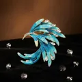 Dettaglio ravvicinato di una lussuosa spilla a uccello in smalto blu e cristalli - Spilla a Coda di Fenice / Blu