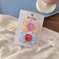 Detail of orange and blue checkered bow hair clips on a white fabric background - Orange Blue Plaid Large Round Bow
