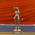 Detailed view of a 7cm tall vintage brass female figurine on a wooden background - Miniskirt Beauty
