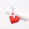 Detail of red faux leather heart pendant with white bow and silver keychain link - Red