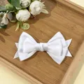 Close-up of white multi-layer bow hair clip on a bamboo tray with floral accents - Spring Clips / White