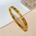 Elegante goudvergulde klaver armband met bloemgravure en kralenrand ontwerp - Groot / Goud