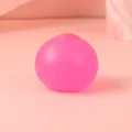Primer plano de pelota antiestrés rosa traslúcida con textura de silicona mate suave - 6cm / Rosa rojo