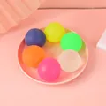 Detailed view of six colorful maltose stress balls arranged in a pink circular tray - 4cm / Random Color