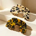 Elegant acetate hair claws in cream and amber leopard print on a minimalist pedestal - Thickened Semicircular Tortoiseshell Claw