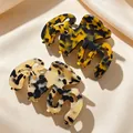 Two tortoise shell acetate hair clips on elegant silk fabric background - Thickened Irregular Hollow Hair Claw