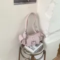 Detail of light pink shoulder bag featuring side pockets and a silver heart pendant - No Pendant / Pink