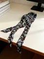 Long silk scarf in dark brown with blue floral print, styled on a desk surface - Deep Blue Camellia