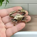 Close-up of vintage bronze crab figurine held in hand showing realistic texture details - Crab Style A