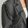 Detail of punk style multi-layer chain brooch with black heart pendant on a grey suit - White K + Black (0385)
