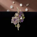 Elegante broche de ramo de rosas con cristales morados y hojas verdes sobre terciopelo - Broche de Ramo de Rosas Púrpuras