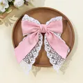 Detail of pink satin bow hair clip with white wide lace trim on wooden tray - Pink