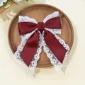 Close-up of elegant burgundy satin ribbon and white floral lace layered hair clip - Burgundy
