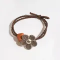 Brown woven elastic hair tie with textured flower charm and geometric bead detail - Brown