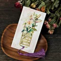 Elegant gold lily flower metal bookmark with purple tassel on dark wooden background - Lily Tassel Style (T01042303)