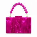 Detail of fuchsia acrylic evening clutch with beaded handle and marble texture finish - Rose Red