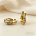 Macro view of gold-plated U-shaped huggie earrings with pave-set shimmering zircon stones - U-Shaped Full Rhinestone Style / Gold