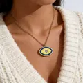 Close-up of golden Evil Eye pendant with blue enamel and crystal on a knit sweater - Dark Blue Yellow Contrast (ADD-202G-5)