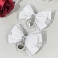 Close-up of white satin bow hair clips with lace, rhinestones and heart cross charms - White Lace Bow Heart Cross Style (10#)