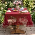 Elegant deep burgundy lace tablecloth with floral patterns and ruffled edges in a garden setting - Red Round Mirror Flower (Ruffled)