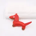 Dettaglio ravvicinato di un ciondolo bassotto in pelle PU rossa con cuciture e inserti - Rosso