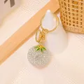 Dettaglio del ciondolo kaki di strass con chiusura in metallo dorato e foglie verdi - Portachiavi Frutta Strass Argento Iridescente (Stile 4)