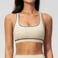 Eng anliegender beiger Yoga-Sport-BH mit schwarzen Kontrastnähten und Racerback - S / Beige Aprikose